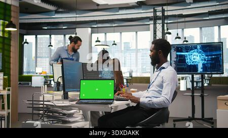 Startup office programmer using green screen laptop, developing artificial intelligence models for business analytics. IT expert using mockup notebook, running simulations for AI forecasting, camera A Stock Photo