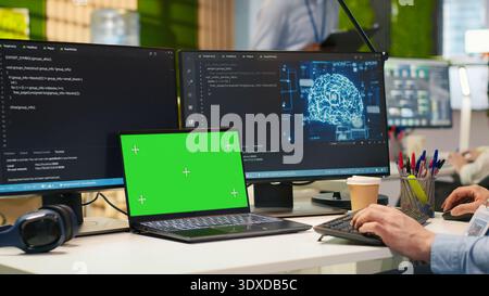 Admin in office using isolated screen laptop, automating repetitive tasks with AI scripts. IT expert using artificial intelligence on chroma key device to speed up feature implementation, camera A Stock Photo