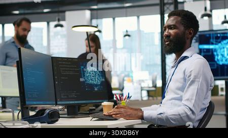 System administrator in office using PC, automating repetitive tasks with AI scripts. IT specialist using artificial intelligence technology to speed up feature implementation, camera A Stock Photo