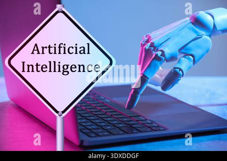 Robot using laptop. Sign with text Artificial Intelligence Stock Photo