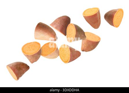 Sweet potato pieces falling against white background Stock Photo