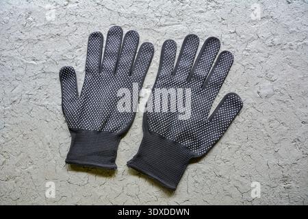 black work gloves is point the finger symbol .Black textile work gloves with rubber. Stock Photo