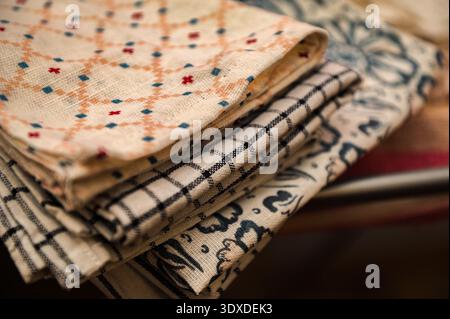 Clean linen towels on the kitchen table, selective focus.Folded kitchen towels. Stock Photo