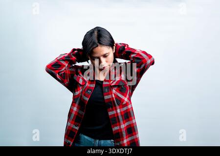 Portrait of a smiling Southeast Asian woman with crossed arms. Isolated studio shot on white background, concept of success and Indonesian youth. Stock Photo
