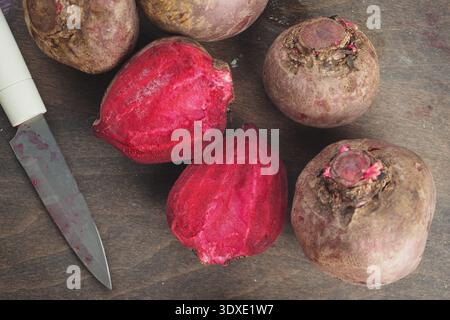 Beets cut open on wooden table with knife nearby Stock Photo