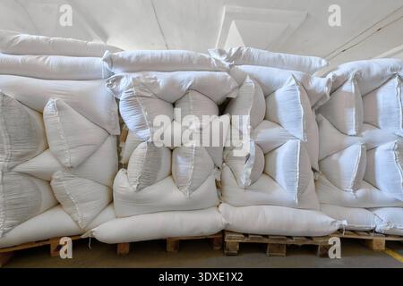 Storage area filled with stacked bags of wheat flour in a warehouse environment for distribution and processing Stock Photo