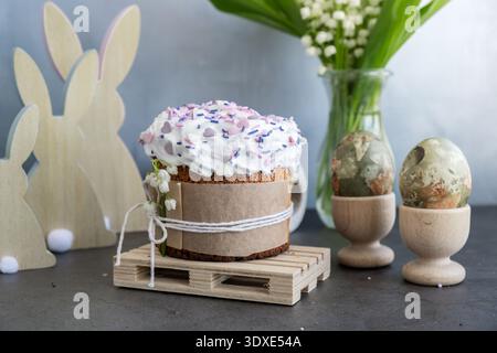 Sweet homemade Easter cake panettone with meringue and creative decoration food. Preparation for Christian holiday Kulich. Easter eggs and bunny on background  Stock Photo