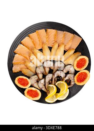 Assorted sliced fish on a black plate. Isolated on white background, top view. Stock Photo