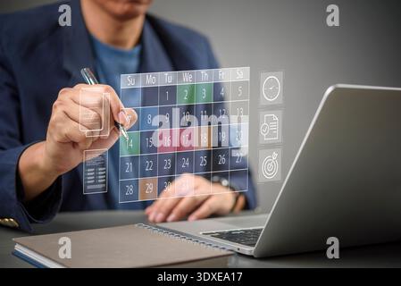 Man scheduling business meeting appointments on digital calendar interface. Focus on efficient planning, organization, daily time management goals, mo Stock Photo