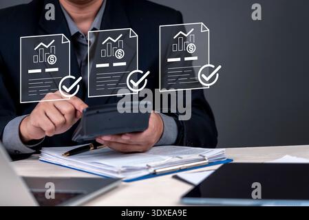 Business finance, accountant using calculator and reviewing digital financial report document icons for data analysis and budget management office. Co Stock Photo