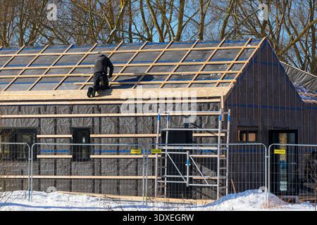 Liepaja, Latvia- 25 February, 2026: Worker Installing Roof Structure on New House in Winter Stock Photo