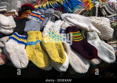 Knitted wool socks.Background knitting wool socks spokes.Winter warm knitted wool sock.multicolor hand knitted different sizes and different colors wa Stock Photo