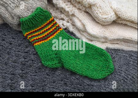 Knitted wool socks.Background knitting wool socks spokes.Winter warm knitted wool sock.multicolor hand knitted different sizes and different colors wa Stock Photo