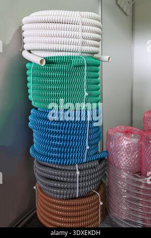 multicolored industrial plastic spiral tubes in zabod packs.Detail of colored plastic hose in spiral shape used in the construction industry for plumb Stock Photo