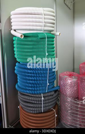 multicolored industrial plastic spiral tubes in zabod packs.Detail of colored plastic hose in spiral shape used in the construction industry for plumb Stock Photo