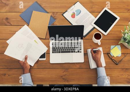 Workspace Collection With Documents, Laptop, Tablet, and Coffee Cup Arranged on Wooden Table Stock Photo