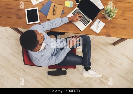 Creative Collage of a Workspace Featuring a Person Using a Laptop While Seated on a Chair Stock Photo