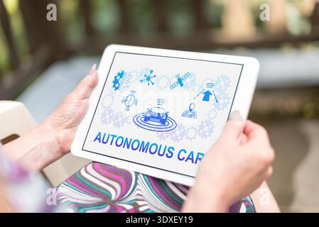 Autonomous car concept shown on a tablet held by a woman Stock Photo