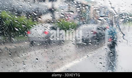 Raindrops on windshield from inside the car in traffic jam. Stock Photo