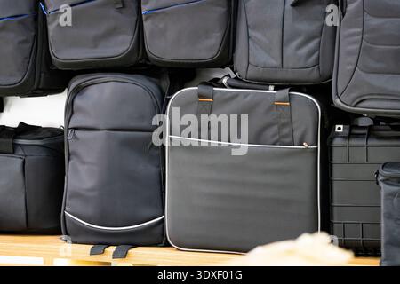 Black travel and laptop bags displayed on shelf in store. Modern backpacks and business luggage concept, retail shopping and travel accessories Stock Photo