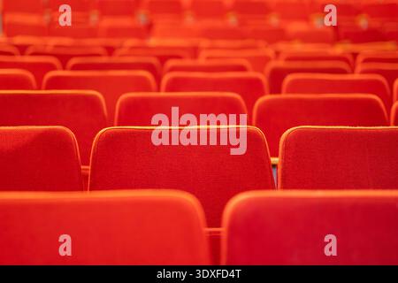 An empty auditorium or theater with red velvet seats, no audience, background. Stock Photo