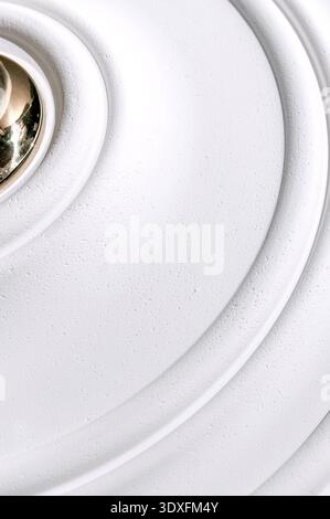 Decorative item made of white plaster on ceiling close-up. Relief stucco interior Stock Photo