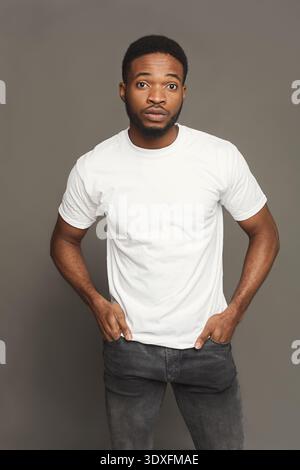 A man stands in profile, looking to the side. He has a gray beard and ...