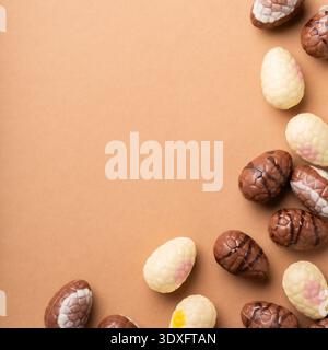 Colorful chocolate Easter eggs arranged on a brown surface, showcasing various designs and textures Stock Photo