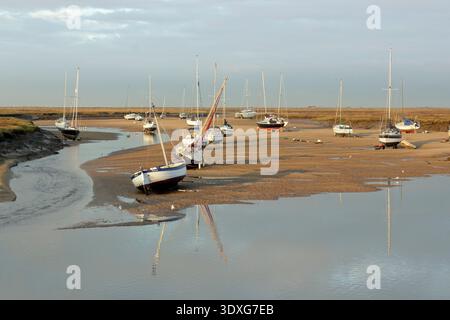Wells next the Sea coastline, North Norfolk. Boats at low tide in the creek at Wells next the Sea harbour. Scenic coastline, Norfolk, UK. Stock Photo