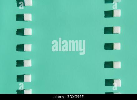 Minimal pattern of sugar cubes on green background with copy space for design Stock Photo