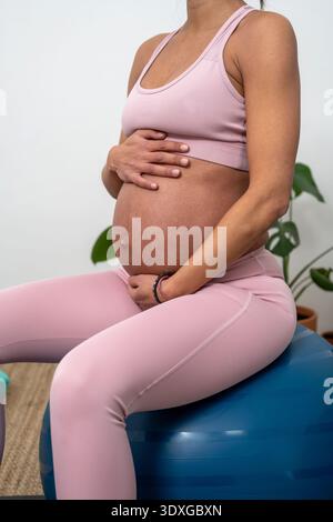 Pregnant Woman Sitting On Stability Ball During Workout Stock Photo