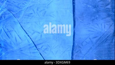 Frozen water shows cracks and patterns in blue color and reveals the coldness of winter in a clear ice setting Stock Photo