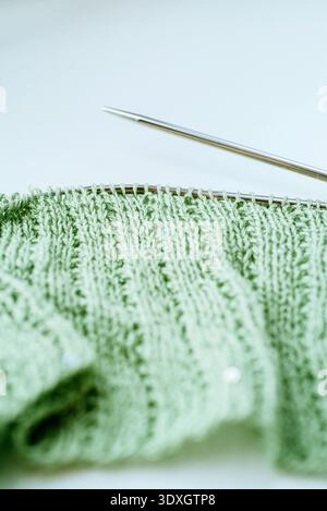 Mint green sequined cotton blend handknit work in progress on circular needles with copy space Stock Photo