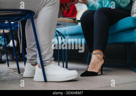 Business collaboration meeting between casual sneakers and formal heels during an informal conversation Stock Photo