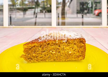 a piece of carrot cake with its characteristic golden-orange hue, showcasing visible pieces of grated carrot, walnuts, and raisins, topped with a gene Stock Photo
