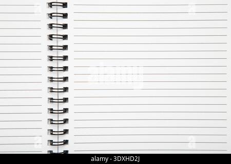 Macro shot of a black metal double-wire spiral binding on white notebook. Top view Stock Photo