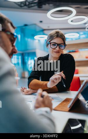 Business meeting in modern office with two professionals collaborating over documents Stock Photo
