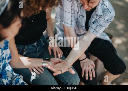 Friends on a sunny day share a moment, showing tattoos and casual style Stock Photo