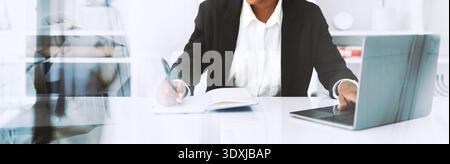 Business Lady Working on Laptop and Taking Notes in Office During Online Tasks Stock Photo