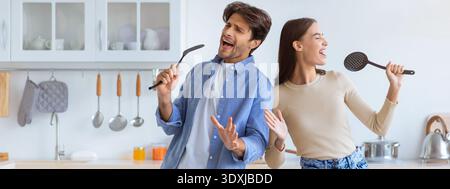 Couple Having Fun While Singing in the Kitchen During the Day Stock Photo
