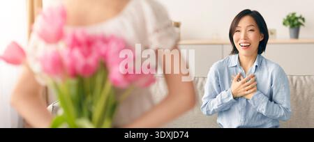 Surprise Moment With Flowers as a Woman Expresses Joy and Gratitude at Home Stock Photo