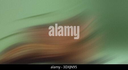 A blurry abstract image featuring shades of green and brown with indistinct shapes and soft lighting Stock Photo