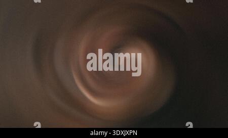 Close up view of a swirling liquid with brown and white tones creating an abstract visual texture effect Stock Photo