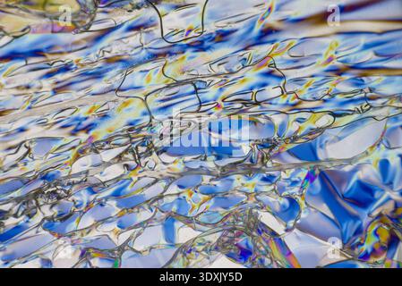 Abstract polarized light microscopy crystal interference patterns with iridescent cell textures. Stock Photo