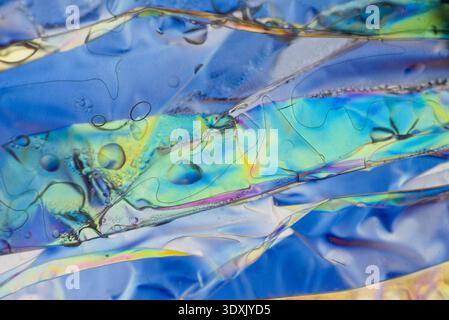 Tiny bubbles on a liquid crystal optical interference macro shot with cyan and green hues. Stock Photo