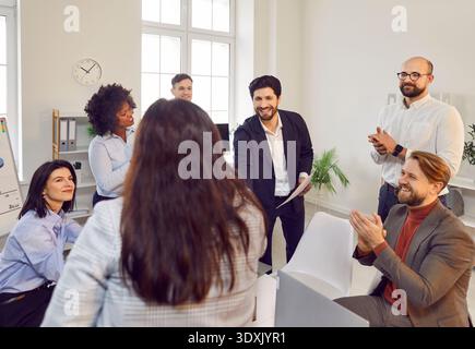 Happy smiling company employees making successful deal in office shaking hands. Stock Photo