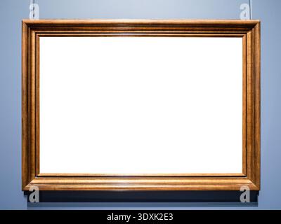 horizontal old wooden brown painting frame with cutout canvas hanging on blue wall Stock Photo