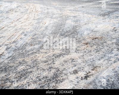 surface of frozen road with dirty snow after clearing in city in winter evening Stock Photo