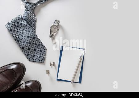 Tie, watch, shoes, cufflinks and card arranged on light background. Fathers Day concept. Business celebration. Minimal style. Stock Photo