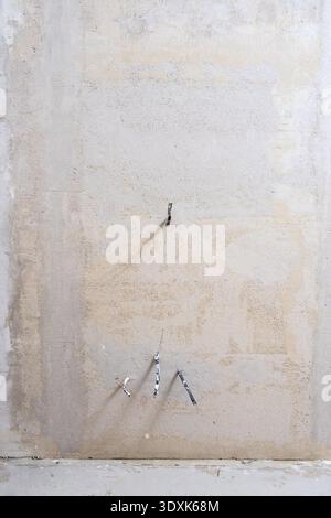 plastered wall with exposed electrical wires during apartment renovation Stock Photo